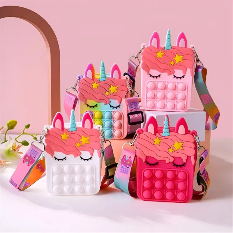 A group of four Unicorn Pop It Sling Bags in various colors (rainbow, white, and pink) with different pop-it bubble colors, displayed together with their colorful straps.
