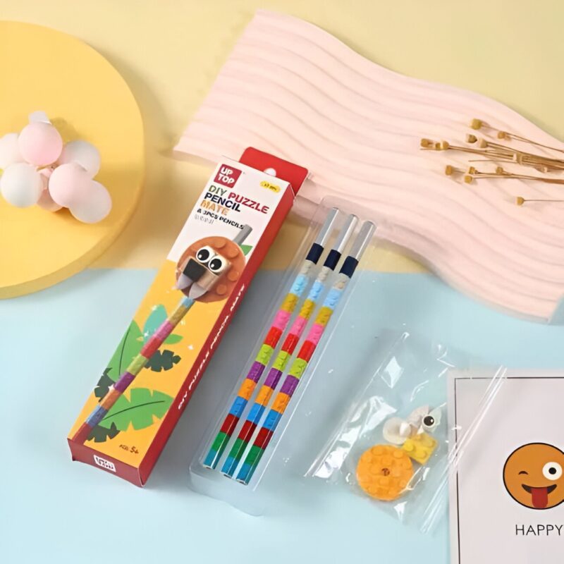 boxed LEGO Pencil set featuring a lion head design, next to three assembled pencils with colorful block segments, and a clear bag containing loose lion puzzle pieces.